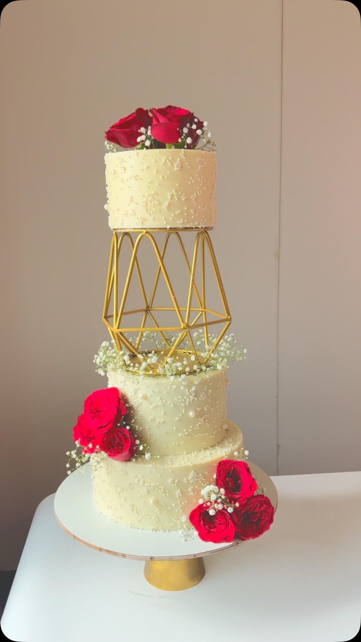 Royal four tier white wedding cake with red roses and gold frame