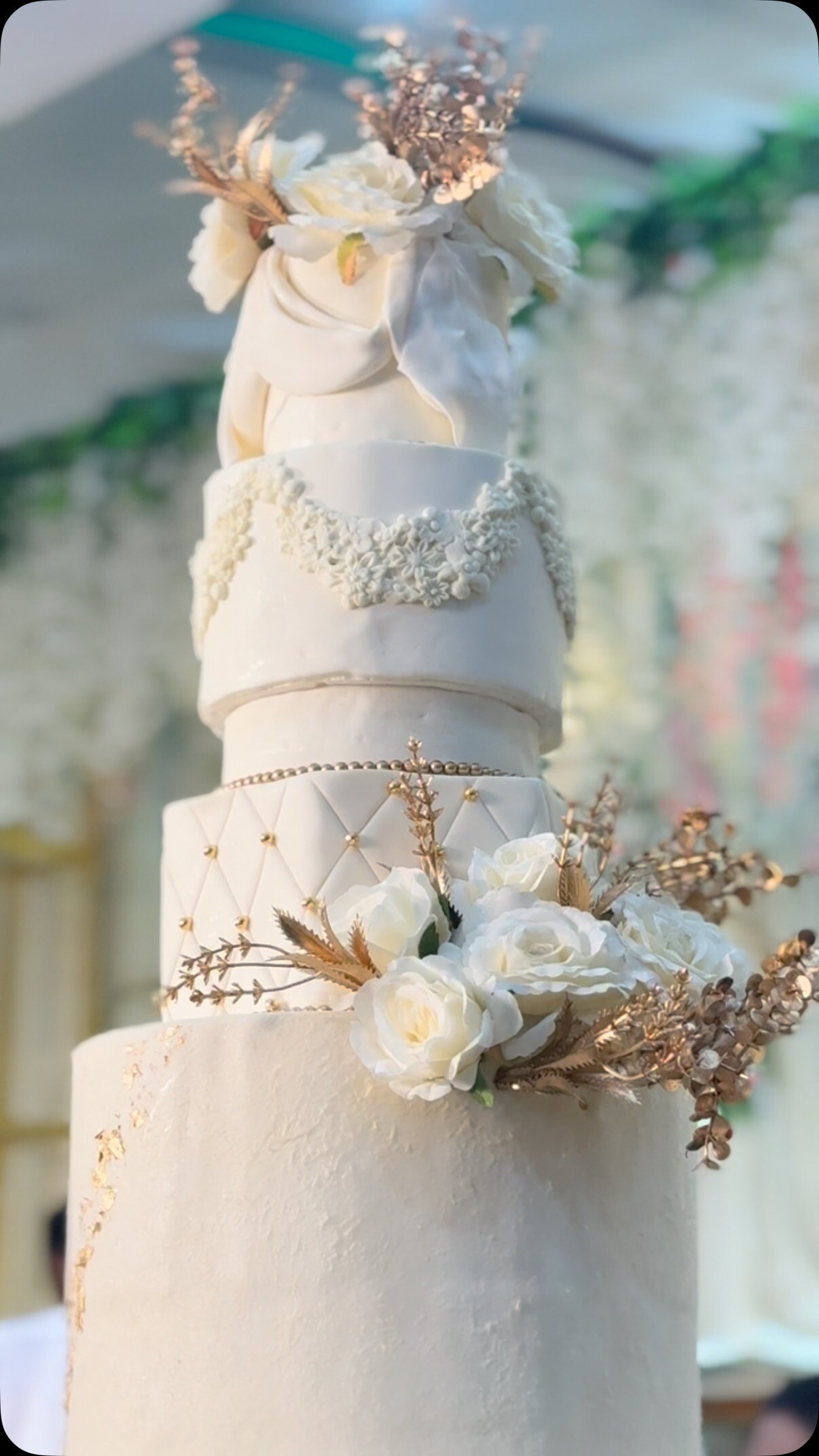 Ivory tiered wedding cake with white roses and dried florals